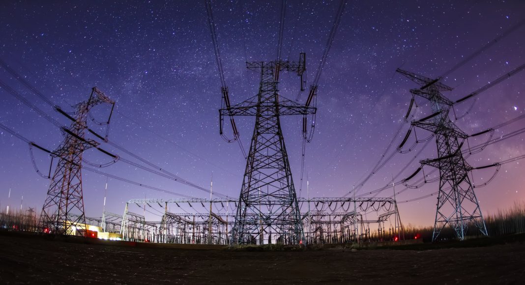 High voltage towers at night and the Milky Way