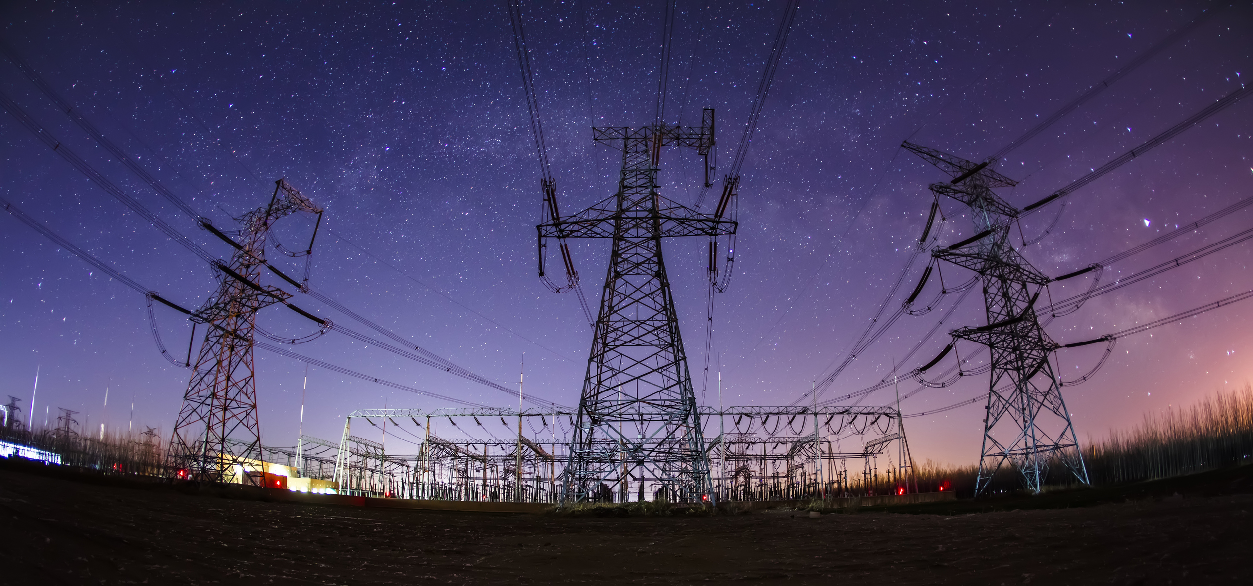 High voltage towers at night and the Milky Way