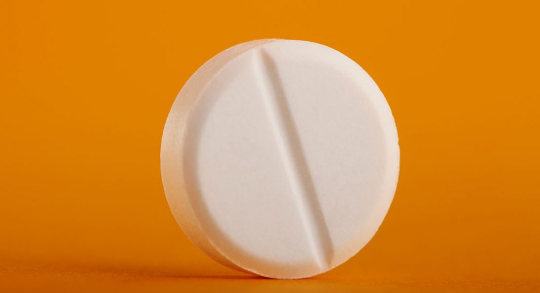 single round pill on a orange-yellow background