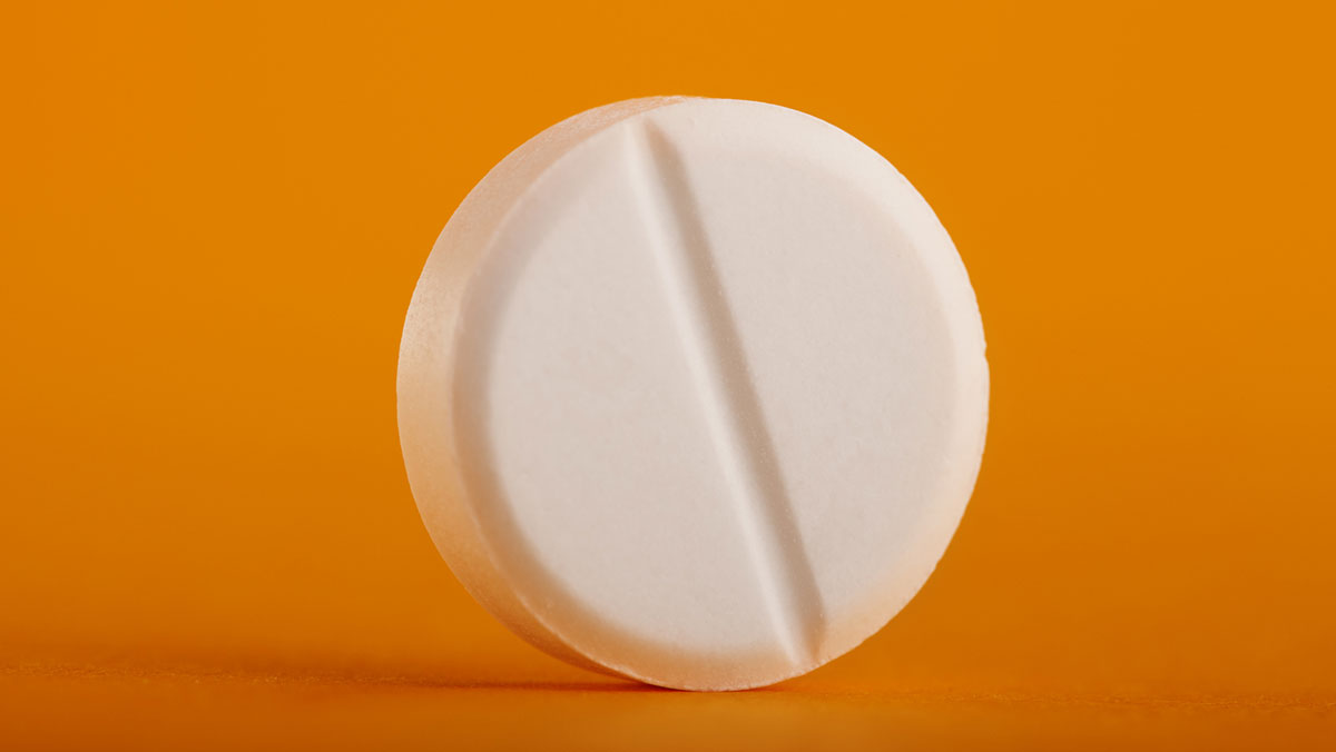 single round pill on a orange-yellow background