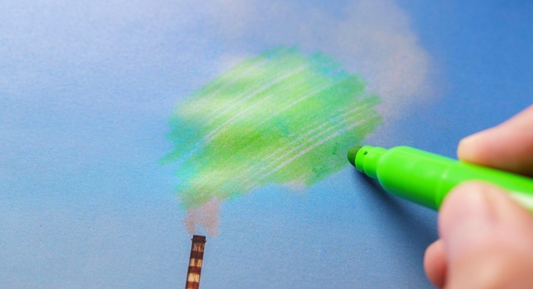 Man painting green pollution from a chimney