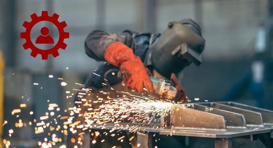 Manual worker on a workshop with a metal grinder