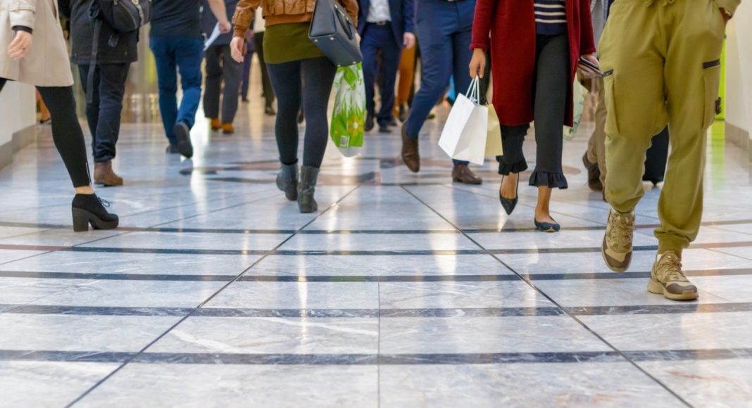 A modern floor with legs of a crowd walking in the background