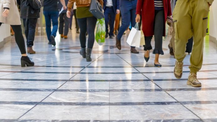 A modern floor with legs of a crowd walking in the background