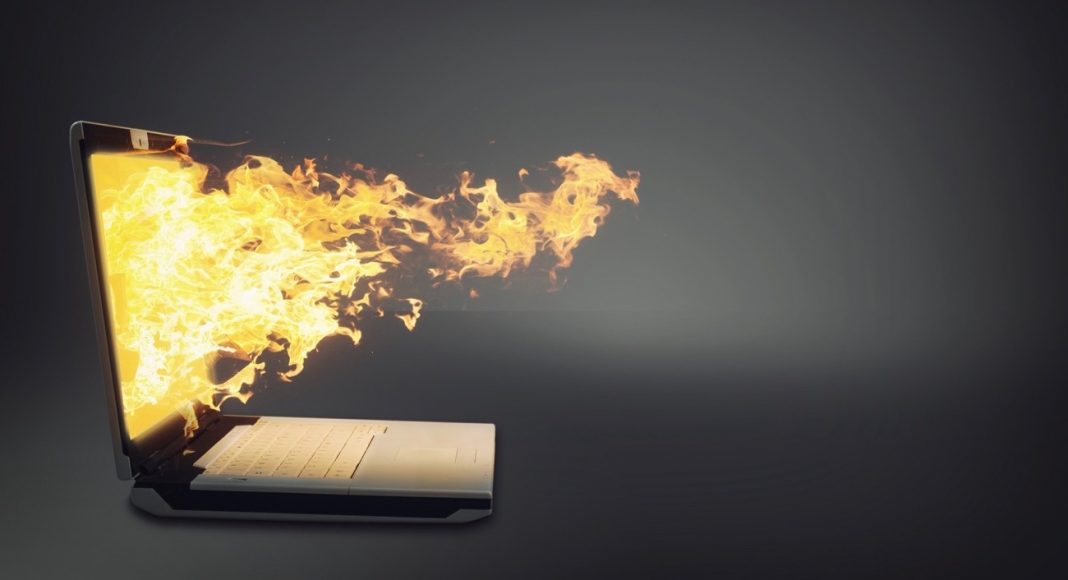 Laptop on fire isolated gray background