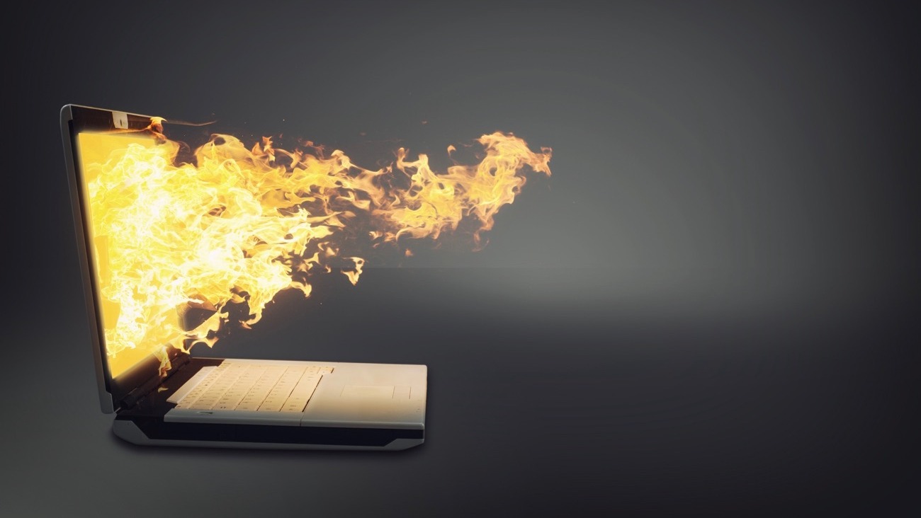 Laptop on fire isolated gray background