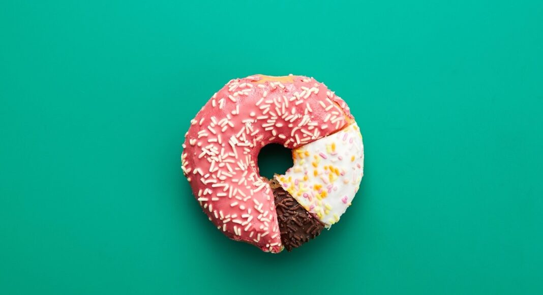 Circular statistical graphic made of doughnuts on green background, comparison chart concept