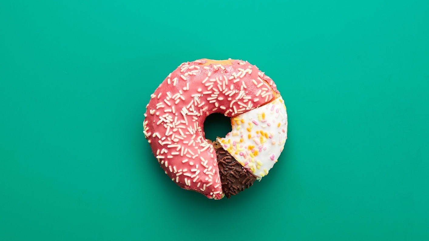 Circular statistical graphic made of doughnuts on green background, comparison chart concept